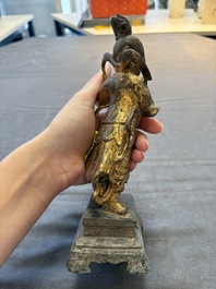 A Chinese bronze Taoist figure and a gilt-lacquered guardian, Ming