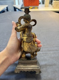 A Chinese bronze Taoist figure and a gilt-lacquered guardian, Ming