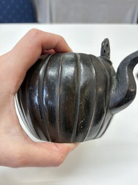 A Chinese bronze teapot and cover with a lion-shaped finial, Yuan