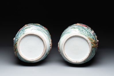 A pair of Chinese famille rose '18 Luohan' vases with relief design, 19th C.