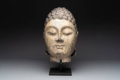 A large Chinese carved stone head of Buddha with traces of gilding and polychromy, Ming