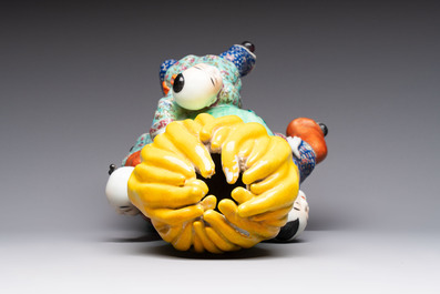A Chinese famille rose figure of three boys holding a Buddha&rsquo;s hand, Republic