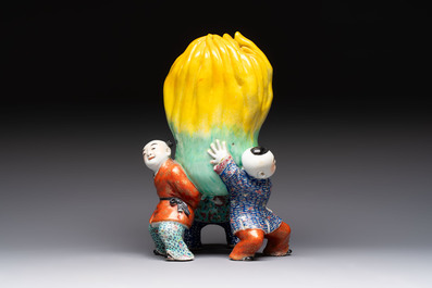 A Chinese famille rose figure of three boys holding a Buddha&rsquo;s hand, Republic