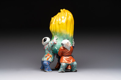 A Chinese famille rose figure of three boys holding a Buddha&rsquo;s hand, Republic
