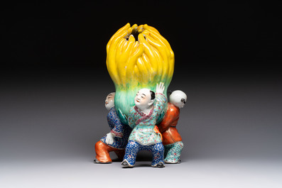 A Chinese famille rose figure of three boys holding a Buddha&rsquo;s hand, Republic