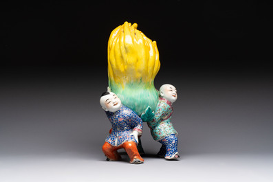 A Chinese famille rose figure of three boys holding a Buddha&rsquo;s hand, Republic