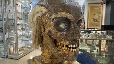 An Italian masked 'petrified' head on giltwood base, mixed media, 19/20th C.