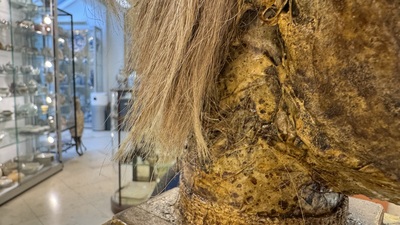 An Italian masked 'petrified' head on giltwood base, mixed media, 19/20th C.