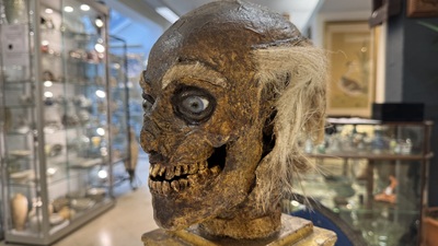 An Italian masked 'petrified' head on giltwood base, mixed media, 19/20th C.