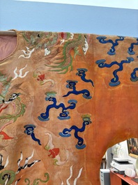 A Chinese embroidered silk salmon-ground 'dragon' robe, 19th C.