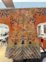 A Chinese embroidered silk salmon-ground 'dragon' robe, 19th C.