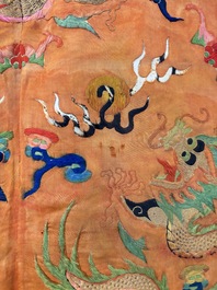 A Chinese embroidered silk salmon-ground 'dragon' robe, 19th C.