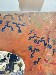 A Chinese embroidered silk salmon-ground 'dragon' robe, 19th C.