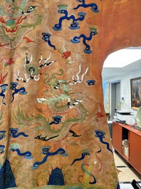 A Chinese embroidered silk salmon-ground 'dragon' robe, 19th C.