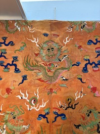 A Chinese embroidered silk salmon-ground 'dragon' robe, 19th C.