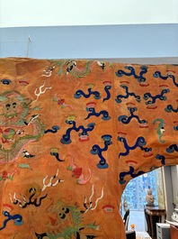 A Chinese embroidered silk salmon-ground 'dragon' robe, 19th C.