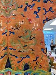 A Chinese embroidered silk salmon-ground 'dragon' robe, 19th C.