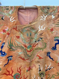 A Chinese embroidered silk salmon-ground 'dragon' robe, 19th C.