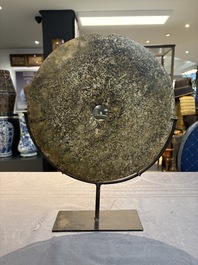 A Chinese archaic calcified jade 'bi' disc on an iron stand, Zhou