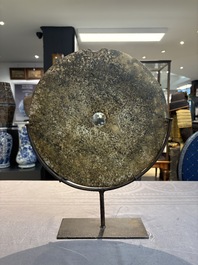 A Chinese archaic calcified jade 'bi' disc on an iron stand, Zhou