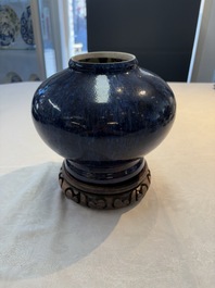 A Chinese flamb&eacute;-glazed vase on a wooden stand, 19th C.