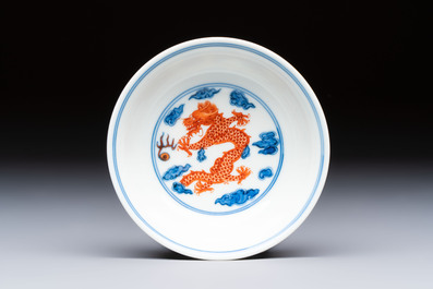 A Chinese iron-red decorated blue and white 'Dragon' saucer and a cup, Yongzheng and Tongzhi mark, 19/20th C.