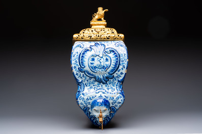 A large blue and white Dutch Delft 'Fountain of Youth' wall cistern with impressive reticulated gilt bronze cover, 18th C.