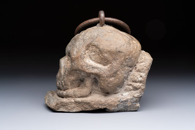 An Italian carved Serena stone 'Memento Mori' in the form of a skull with a wrought-iron suspension ring, probably Tuscany, 17th C.
