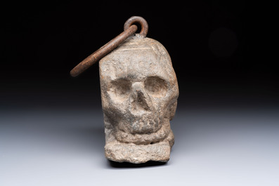 An Italian carved Serena stone 'Memento Mori' in the form of a skull with a wrought-iron suspension ring, probably Tuscany, 17th C.