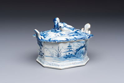 A blue and white Dutch Delft chinoiserie butter tub with a reclining figure finial, 18th C.