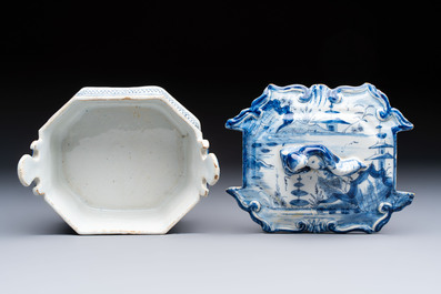 A blue and white Dutch Delft chinoiserie butter tub with a reclining figure finial, 18th C.