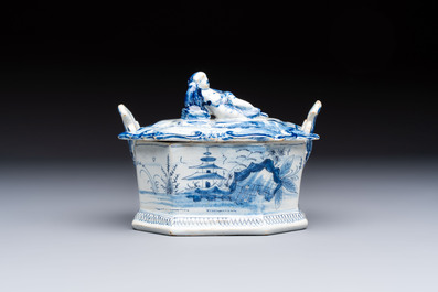 A blue and white Dutch Delft chinoiserie butter tub with a reclining figure finial, 18th C.