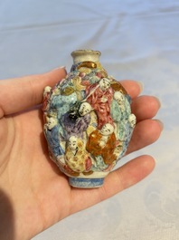 A Chinese famille rose moulded '18 Luohan' snuff bottle, Qianlong mark, 19th C.