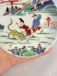 A pair of Chinese famille rose 'Taming the Tiger' saucers, Yongzheng