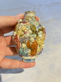 A Chinese famille rose moulded '18 Luohan' snuff bottle, Qianlong mark, 19th C.