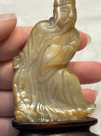 A Chinese carved mother-of-pearl figure of an official on wooden stand, 18/19th C.