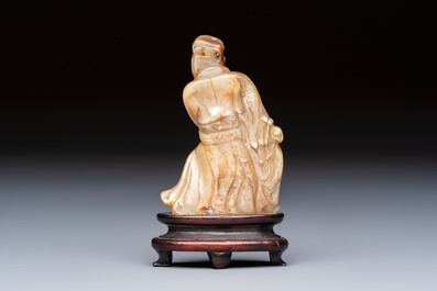 A Chinese carved mother-of-pearl figure of an official on wooden stand, 18/19th C.