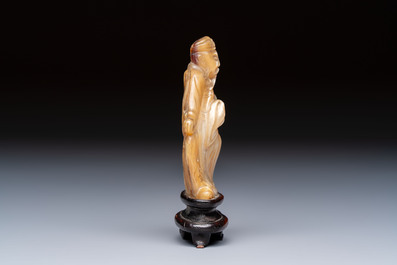 A Chinese carved mother-of-pearl figure of an official on wooden stand, 18/19th C.