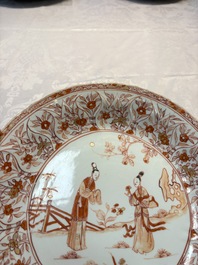A pair of Chinese iron-red and gilt-decorated 'Elegant Beauties in a Garden' dishes, Kangxi