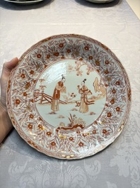 A pair of Chinese iron-red and gilt-decorated 'Elegant Beauties in a Garden' dishes, Kangxi