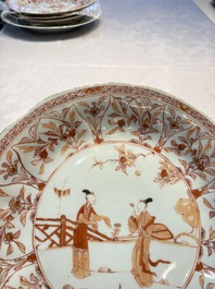 A pair of Chinese iron-red and gilt-decorated 'Elegant Beauties in a Garden' dishes, Kangxi