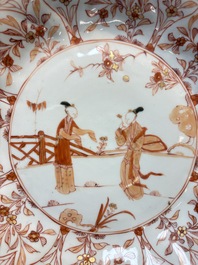 A pair of Chinese iron-red and gilt-decorated 'Elegant Beauties in a Garden' dishes, Kangxi