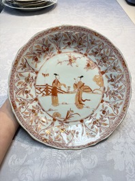 A pair of Chinese iron-red and gilt-decorated 'Elegant Beauties in a Garden' dishes, Kangxi