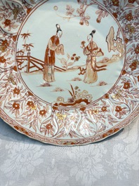 A pair of Chinese iron-red and gilt-decorated 'Elegant Beauties in a Garden' dishes, Kangxi