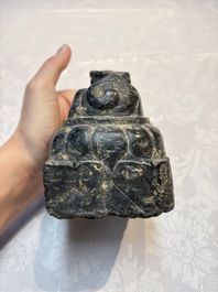 A Chinese carved black stone paper weight in the shape of a reclining buffalo on a lotus throne, Northern and Southern dynasties