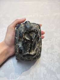 A Chinese carved black stone paper weight in the shape of a reclining buffalo on a lotus throne, Northern and Southern dynasties