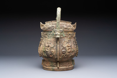 A Chinese archaic bronze wine vessel and cover with Taotie design, You 卣, late Shang