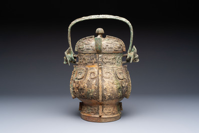 A Chinese archaic bronze wine vessel and cover with Taotie design, You 卣, late Shang