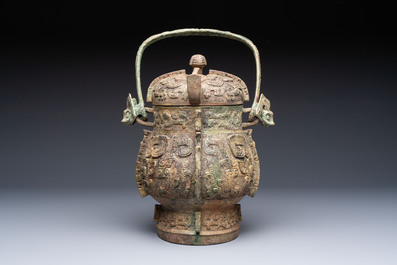A Chinese archaic bronze wine vessel and cover with Taotie design, You 卣, late Shang