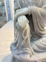 An exceptional and large Chinese carved pale lavender jadeite Guanyin on a wooden stand, Republic